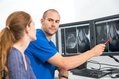 Radiologist councelling a patient using MRI images photo