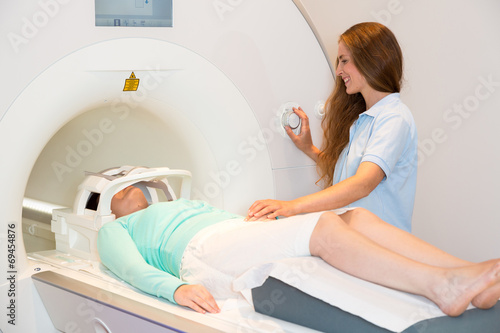 Medical technical assistant preparing scan of patient with MRI
