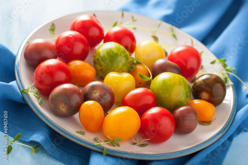 colorful tomatoes in plate on blue background