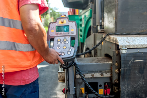 Obraz na płótnie close up of worker hand operating asphalt paver machinery
