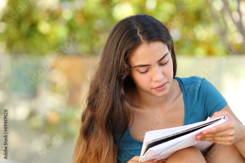 Beautiful student teen girl studying in a park