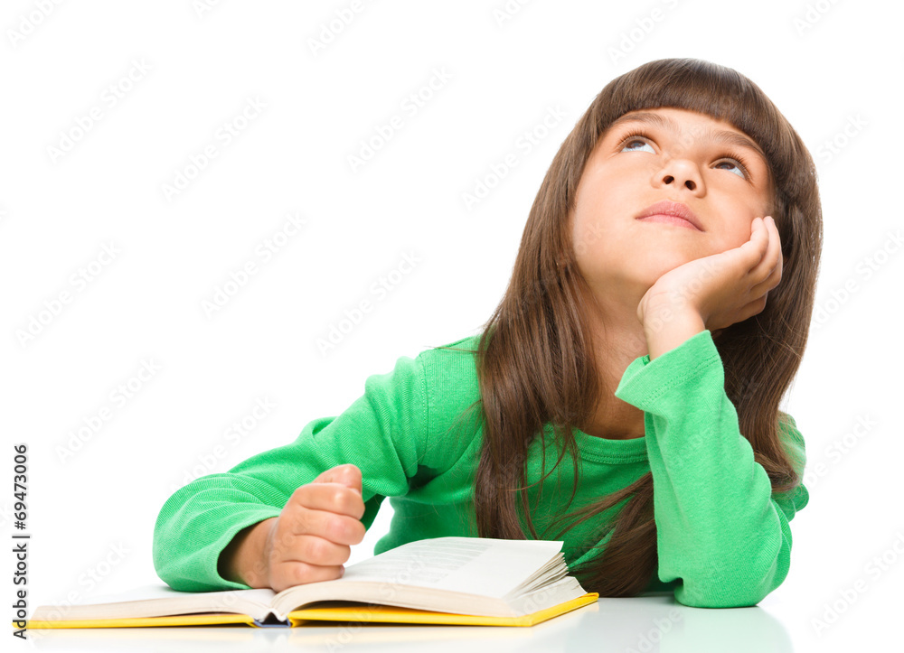 Young girl is daydreaming while reading book Young girl is daydreaming while reading book