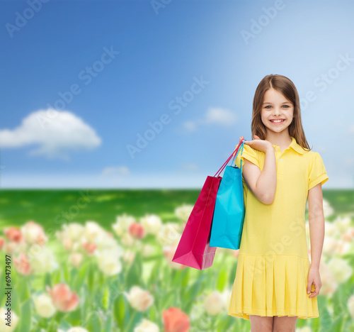 smiling little girl in dress with shopping bags