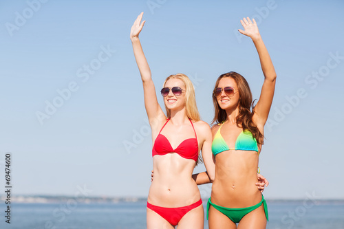 two smiling young women on beach