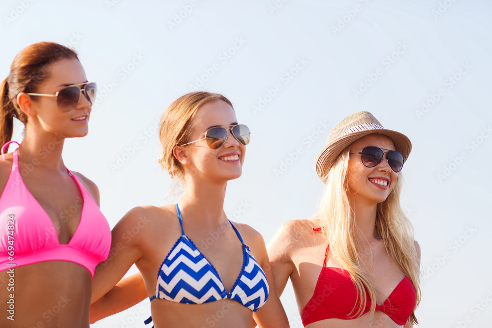 group of smiling young women in sunglasses