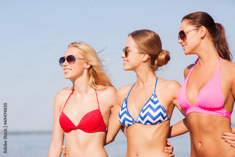 group of smiling young women in sunglasses