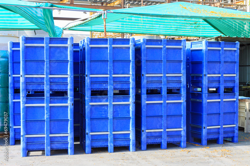 Big blue containers under green tent