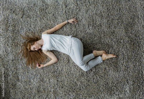 фотографія Young woman laying on the carpet