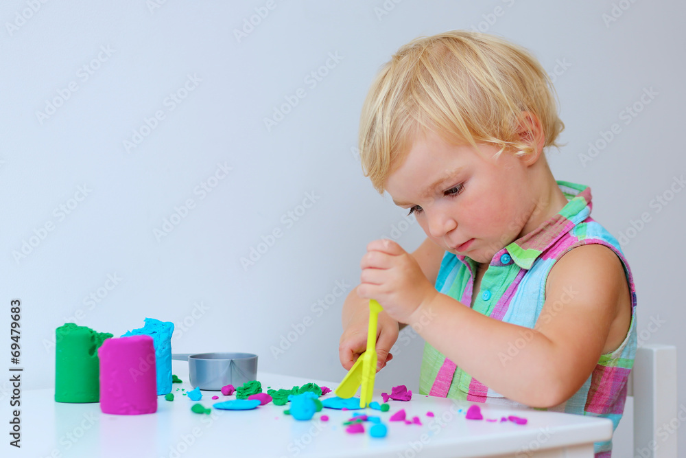 Cute preschooler girl playing with colorful compound dough Cute preschooler girl playing with colorful compound dough