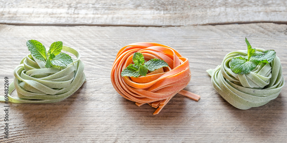 Colorful rolled pasta on the wooden background Colorful rolled pasta on the wooden background