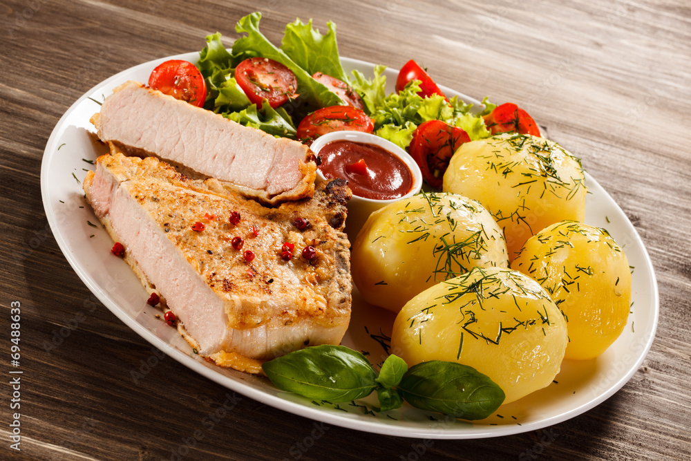 Fried pork chop, boiled potatoes and vegetable salad Fried pork chop, boiled potatoes and vegetable salad