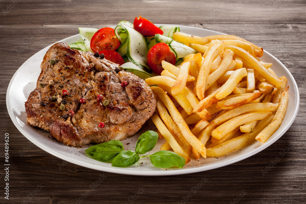 Grilled steak, French fries and vegetables Grilled steak, French fries and vegetables