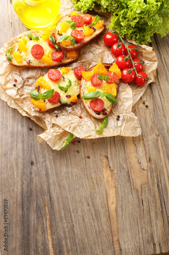 Tasty bruschetta with tomatoes, on old wooden table