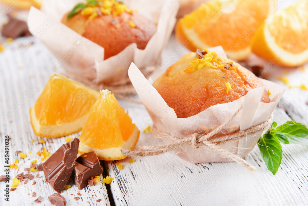 Tasty cupcakes with orange on table close-up Tasty cupcakes with orange on table close-up