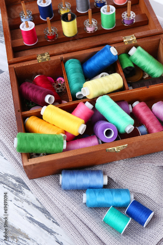 Colorful threads for needlework in wooden box close up