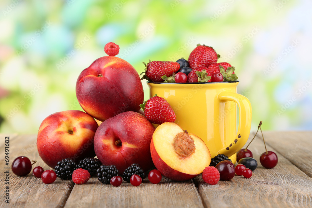 Peaches and berries on table on natural background Peaches and berries on table on natural background