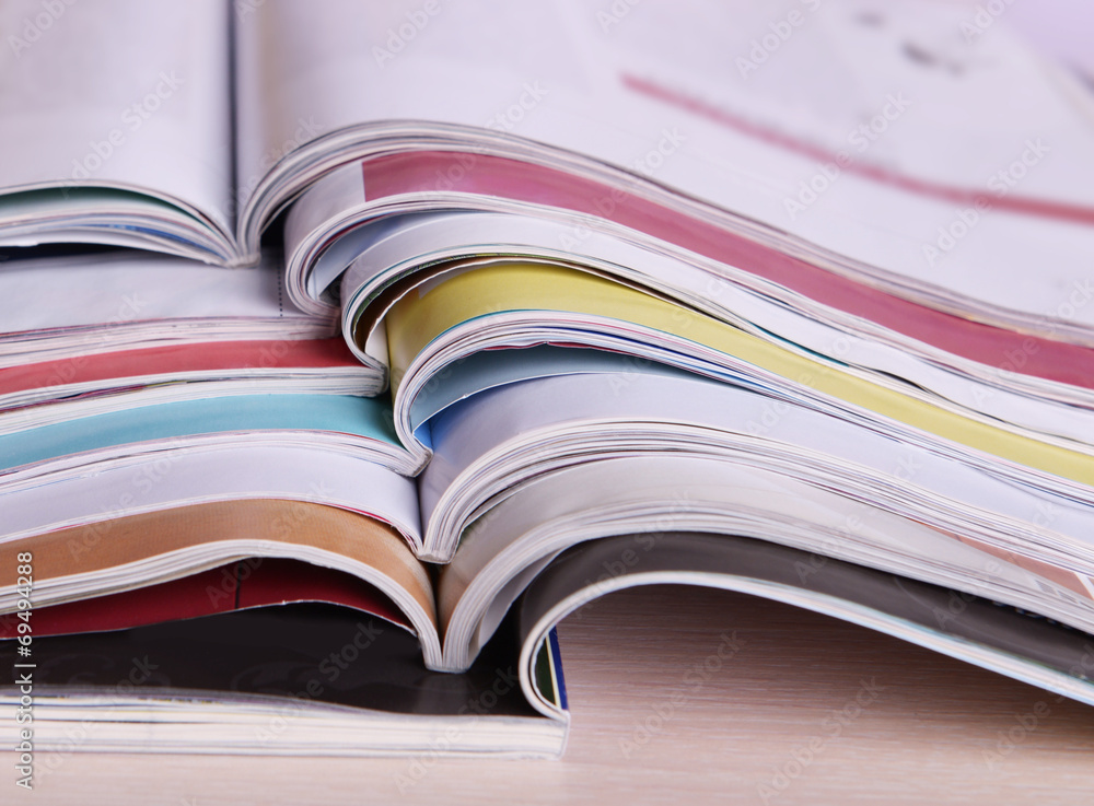 Magazines on wooden table on bright background Magazines on wooden table on bright background