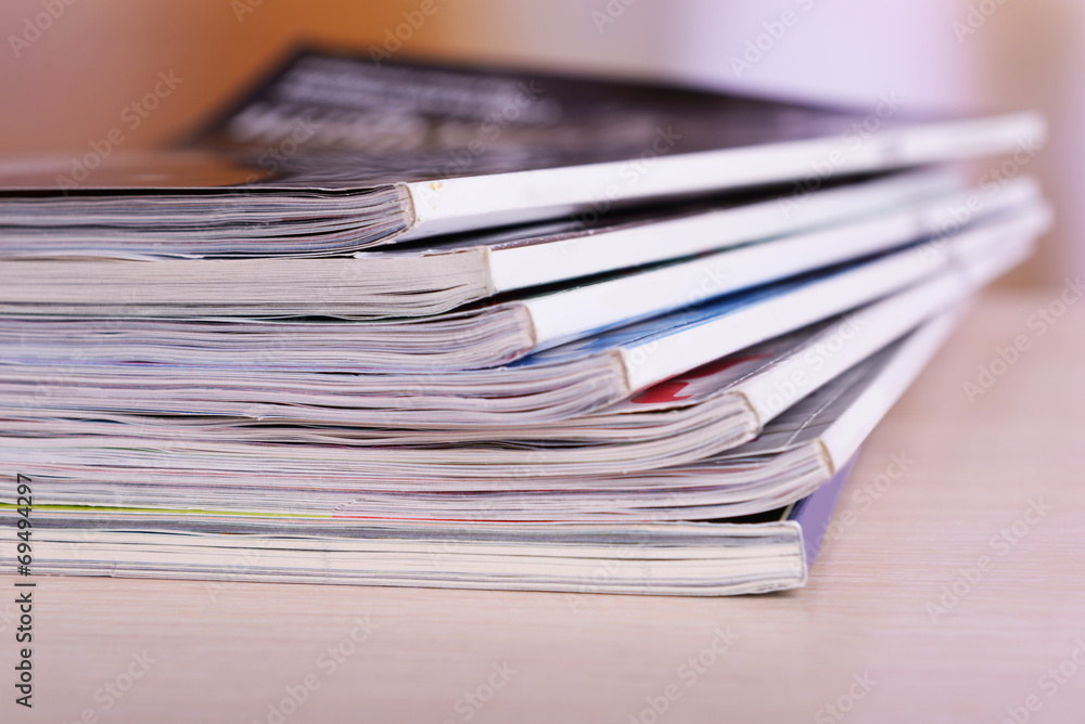 Magazines on wooden table on bright background Magazines on wooden table on bright background