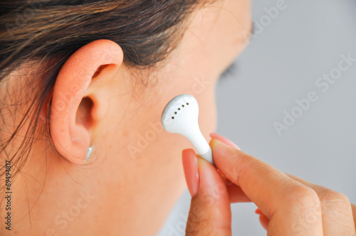 Woman putting headphones in ear