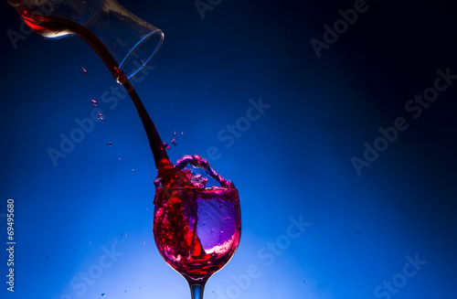 splash glass red wine blue background