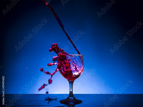 splash glass red wine blue background