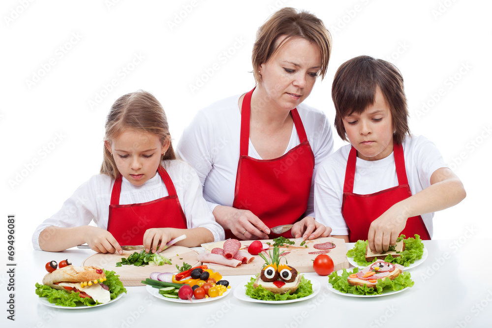 Kids and their mother preapring the party sandwiches Kids and their mother preapring the party sandwiches