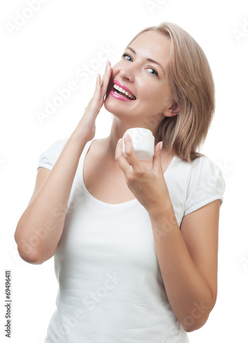 Beautiful woman gets cream on face isolated on white