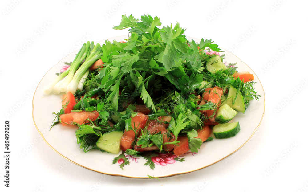 Salad of fresh greens and fruit on a plate. Isolated object on w