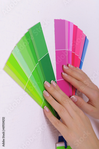 Woman choosing color for wall from swatches in room © Africa Studio