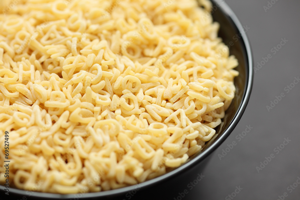 Raw alphabet soup pasta in a bowl Raw alphabet soup pasta in a bowl