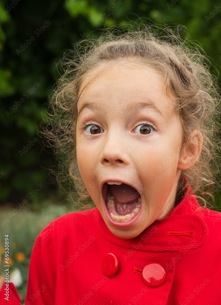 Little girlin red jacket is suprised and so happy about it. Little girlin red jacket is suprised and so happy about it.