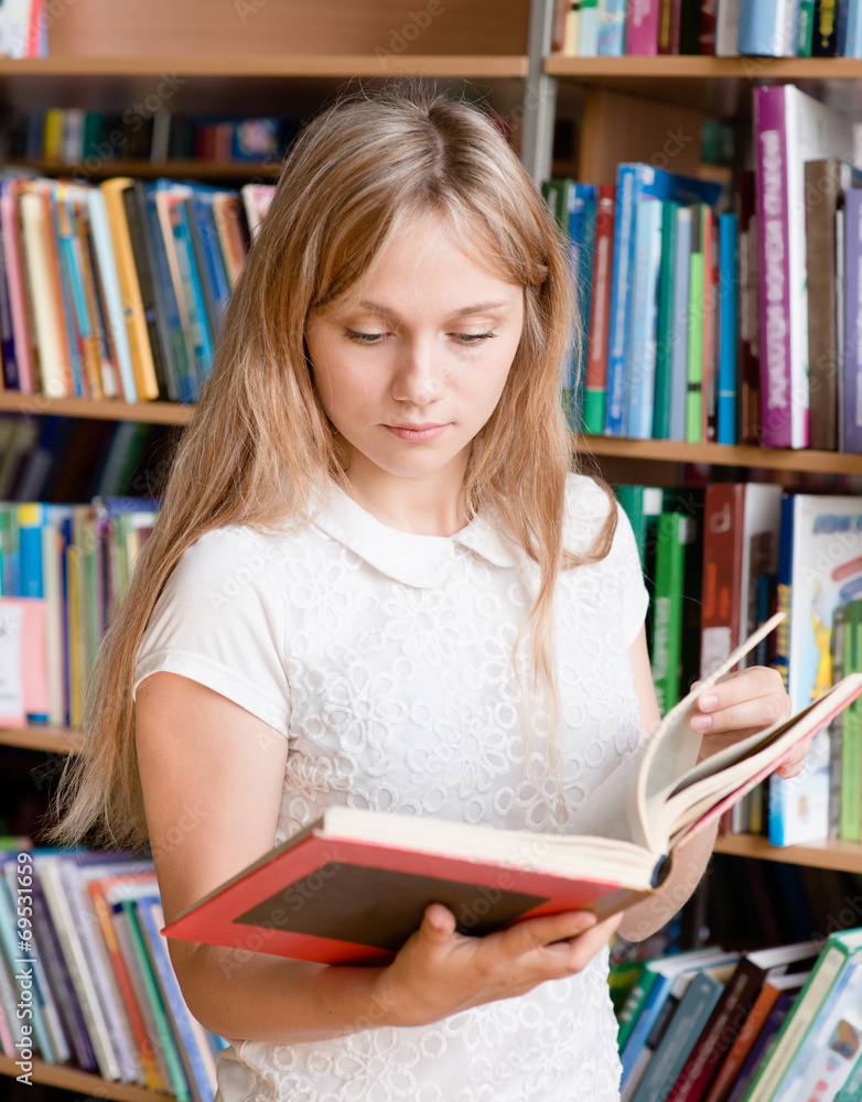 female student reading book in library female student reading book in library