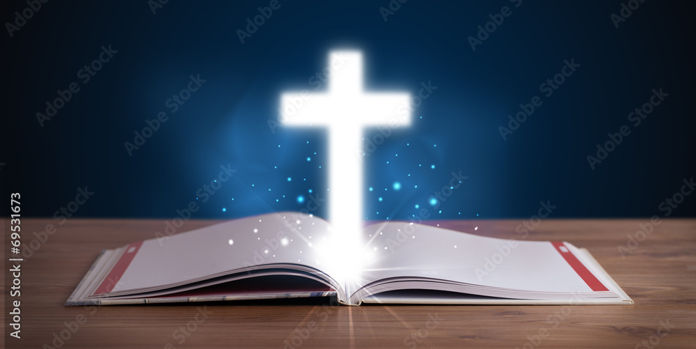 Open holy bible with glowing cross in the middle Open holy bible with glowing cross in the middle