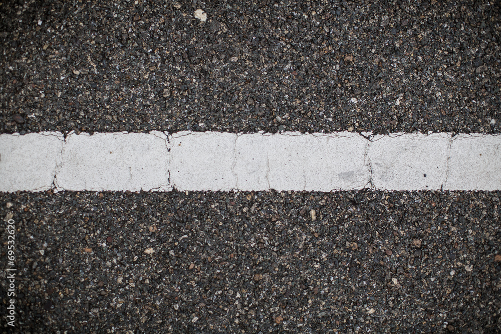 Fototapeta premium Asphalt road with marking lines. Close-up background texture