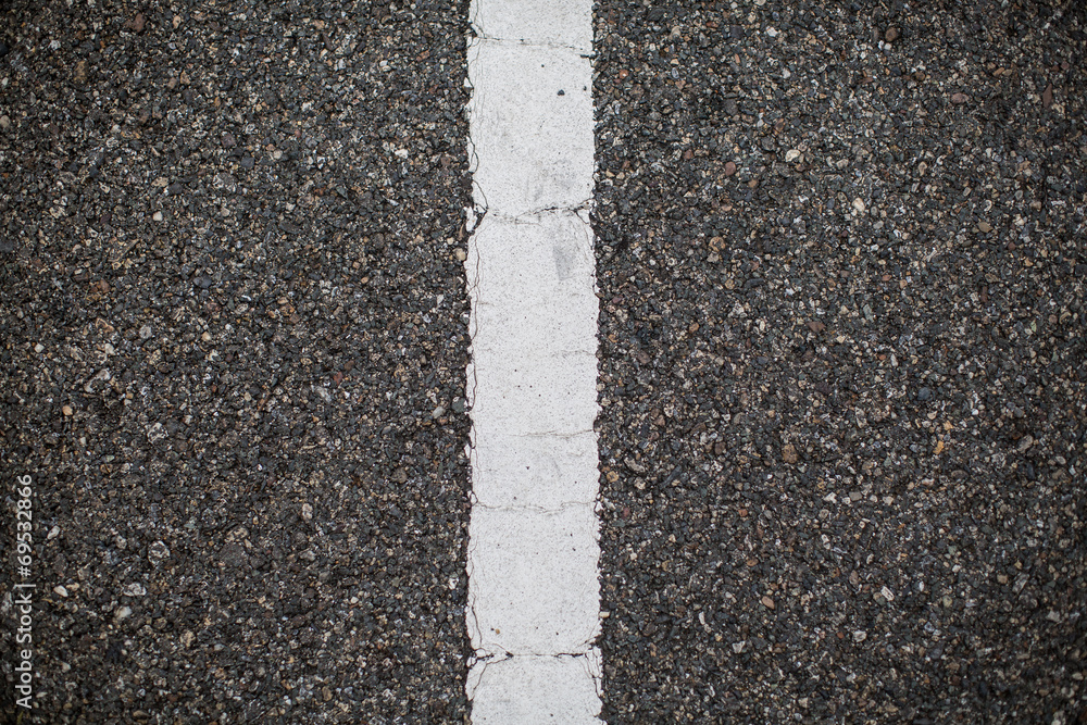 Fototapeta premium Asphalt road with marking lines. Close-up background texture