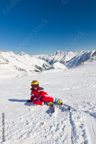 Girl skier sitting on a ski slope