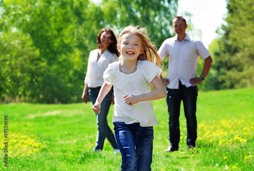 Happy young girl running from her parents
