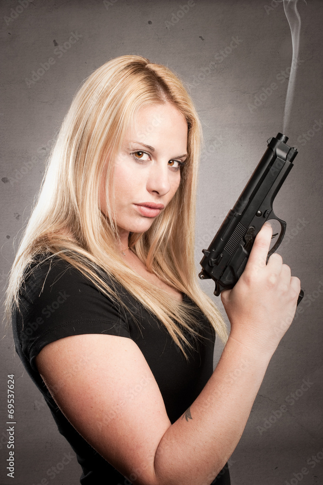 woman with a gun on gray background