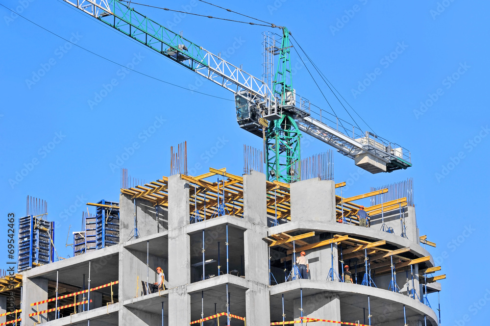 Crane and building construction site against blue sky Crane and building construction site against blue sky