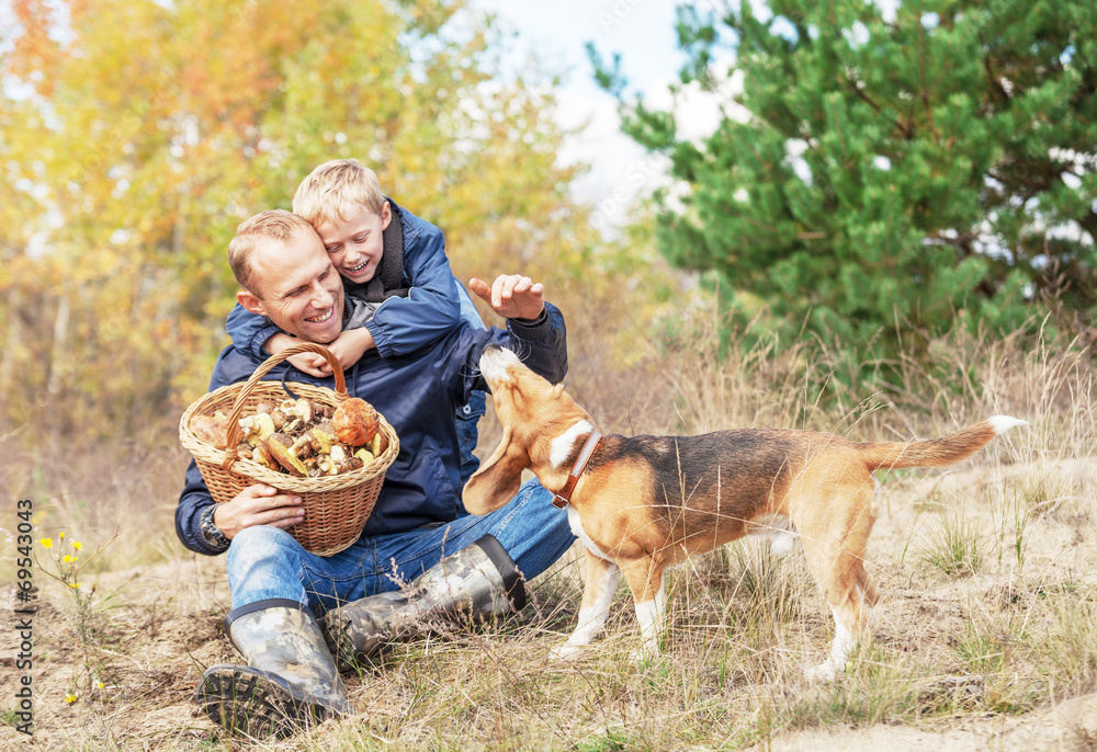 Father with son playing with dog on autumn forest glade Father with son playing with dog on autumn forest glade