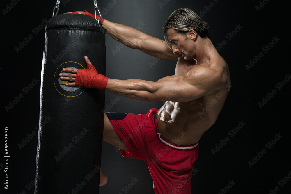 Mature Man Exercising Bag Boxing In Studio