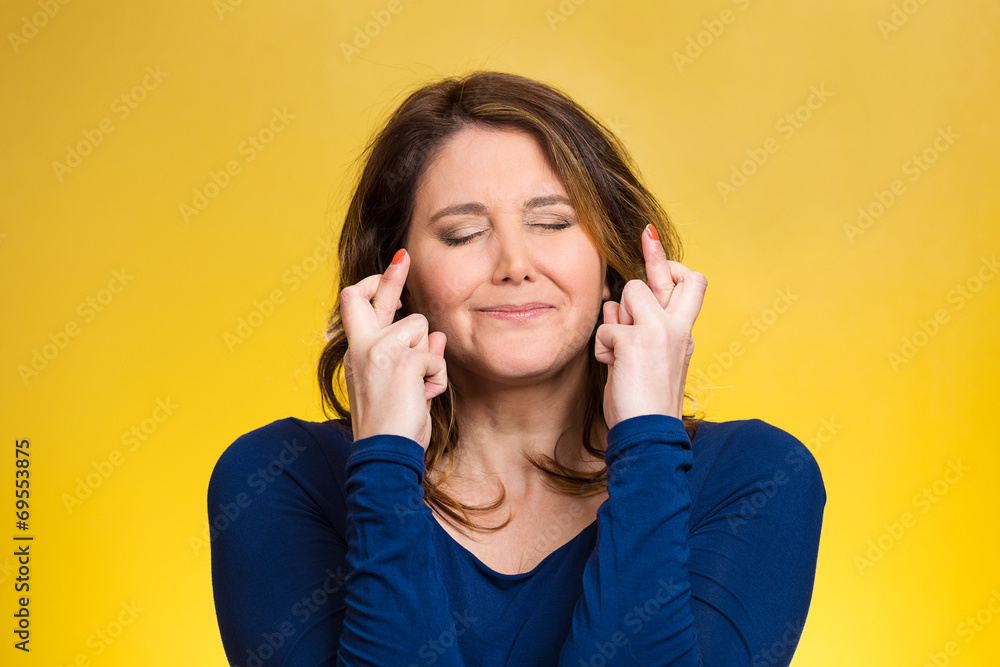 Woman, mother crossing her fingers on yellow background Woman, mother crossing her fingers on yellow background
