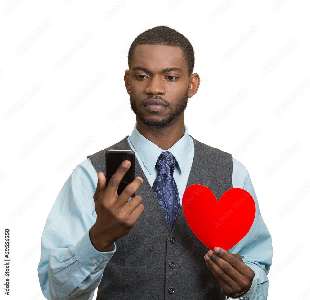 Man reading news, on smart phone, holding red heart Man reading news, on smart phone, holding red heart