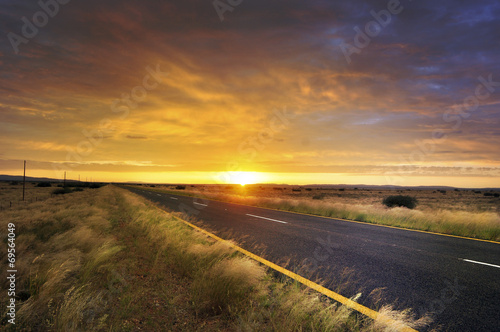 Long road through African country side at sunrise