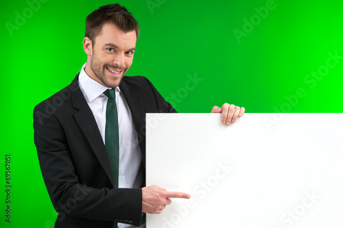 Happy smiling business man showing blank signboard.