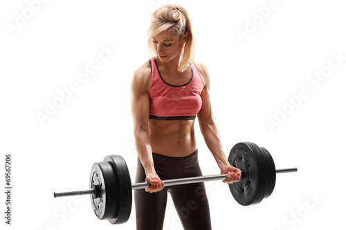 Attractive female athlete exercising with barbell