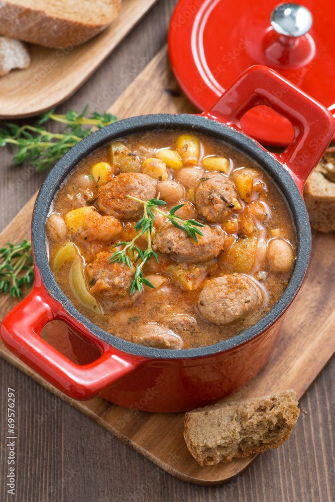 delicious vegetable stew with sausages in a pan, top view delicious vegetable stew with sausages in a pan, top view