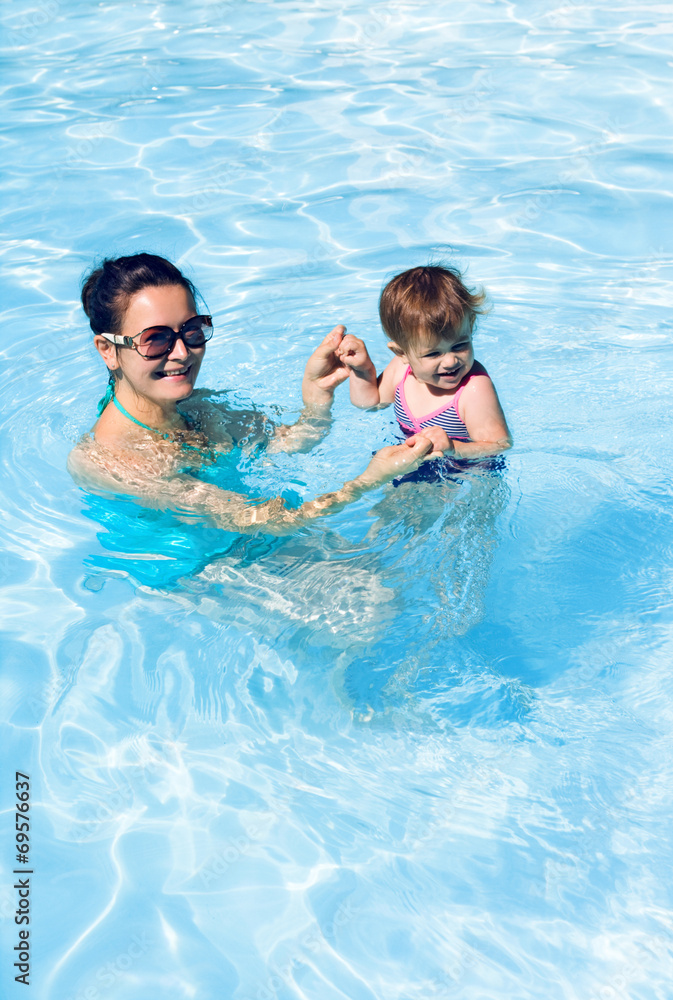 Family in swimming pool playing