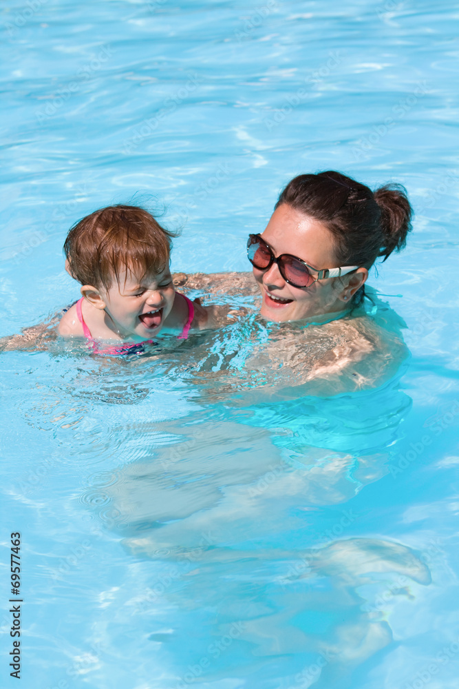 Family in swimming pool playing