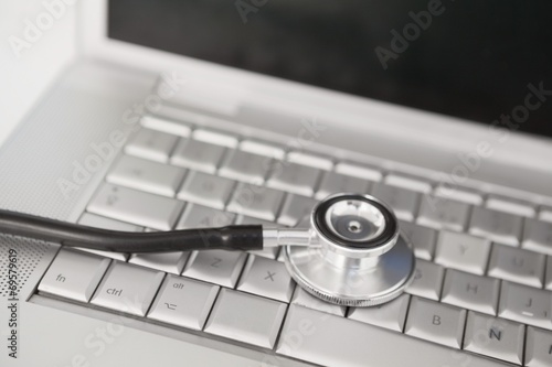 Stethoscope lying on silver laptop